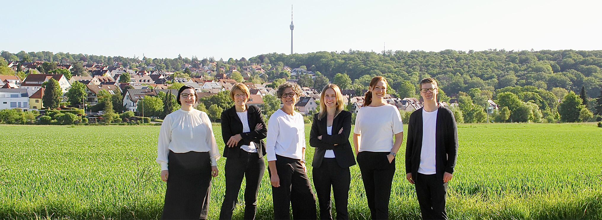 Mitarbeiterin der Bestattungsschmiede Stuttgart in einem stilvollen Beratungsraum mit zwei Holzsärgen im Hintergrund. Die Raumgestaltung mit Laternen, Efeu und sanftem Tageslicht schafft eine ruhige und einfühlsame Atmosphäre für Abschied und Trauergespräche.